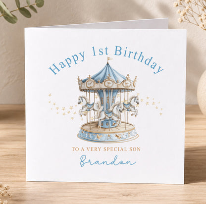 Personalised first birthday card featuring a blue horse and carousel merry-go-round design, printed with a custom name and birthday message.