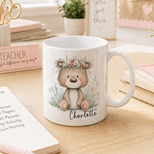 White ceramic mug printed with a teddy bear and floral design, personalised with a name