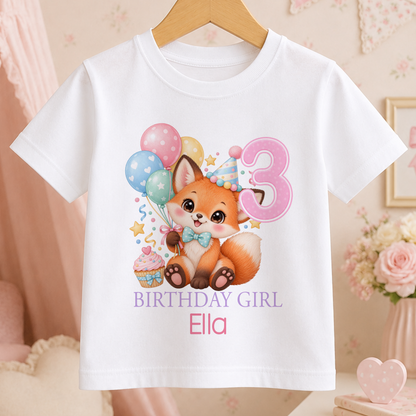 Personalised white t-shirt with a watercolour party fox, pastel balloons and a cupcake, an age number and Birthday Girl above a name