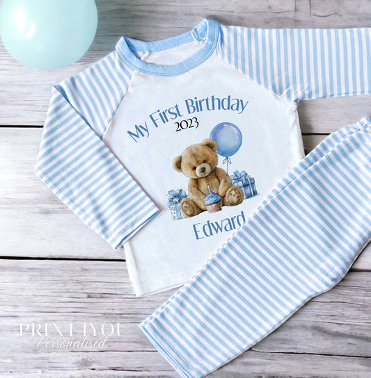 Personalised blue stripe teddy bear pyjamas for a baby's first birthday, printed with a custom name.