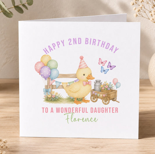 A personalised birthday card featuring a yellow duck wearing a party hat, surrounded by colourful balloons, flowers and a wagon, with the message 'Happy 2nd Birthday to a wonderful daughter Florence'.