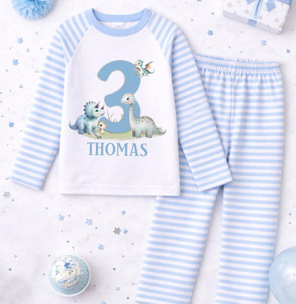 Close-up of the dinosaur motif, personalised name and age printed on the blue stripe pyjama top