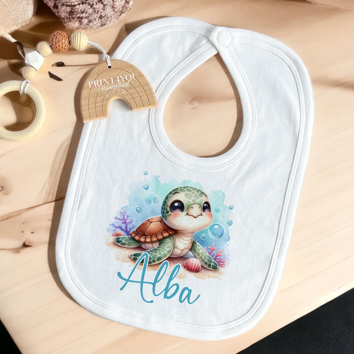 Personalised Sea Turtle baby vest laid flat, showing the printed name.