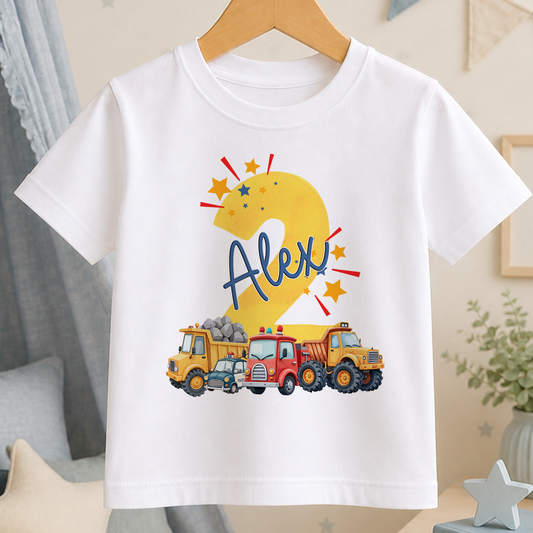 A white t-shirt with a graphic design featuring a yellow number 2 and various construction vehicles, including a fire truck and a dump truck.