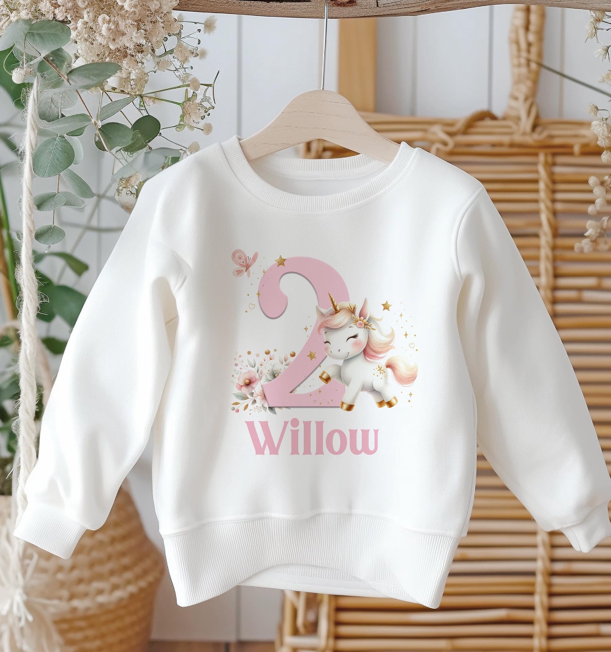 Child wearing the personalised white cotton unicorn birthday sweatshirt with printed name and age number.
