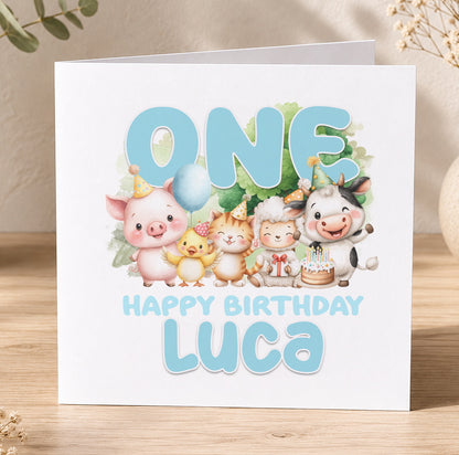 First birthday card illustrated with a pig, cat, cow and duck, printed with 'One Happy Birthday Luca' as a personalisation example.