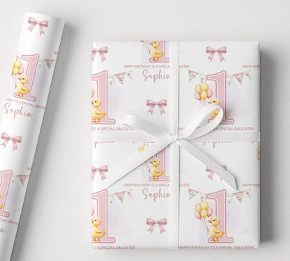 Personalised 1st birthday wrapping paper with pink duck design, custom name and relation, large number 1, balloons, bunting and bow details.