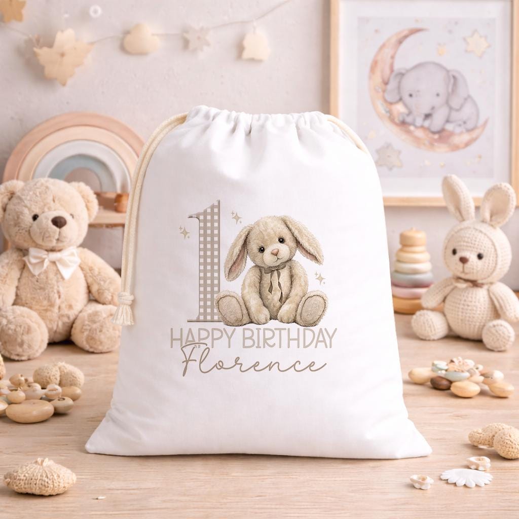 Personalised teddy and bunny birthday sack laid flat, showing the printed name and drawstring top