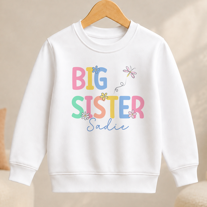 A white children's sweatshirt with the text "BIG SISTER Sadie" printed on it.