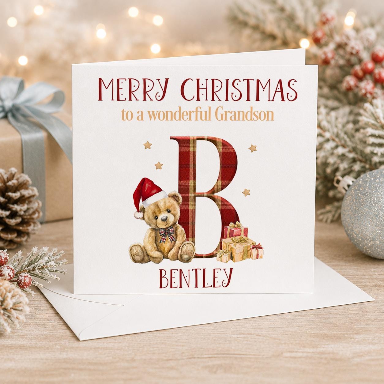 Personalised Christmas card, white 6x6 inch square card printed with a large red initial, a teddy bear in a Santa hat, Merry Christmas and a name