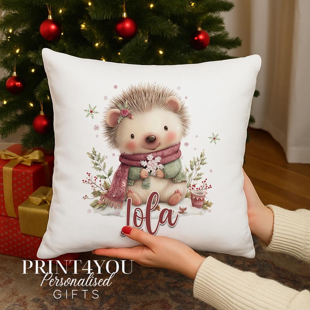 Personalised hedgehog Christmas cushion cover with a hedgehog in a winter scarf surrounded by festive foliage and custom name