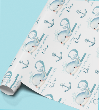 Flat lay of the personalised whale birthday wrapping paper showing the repeat whale and anchor pattern
