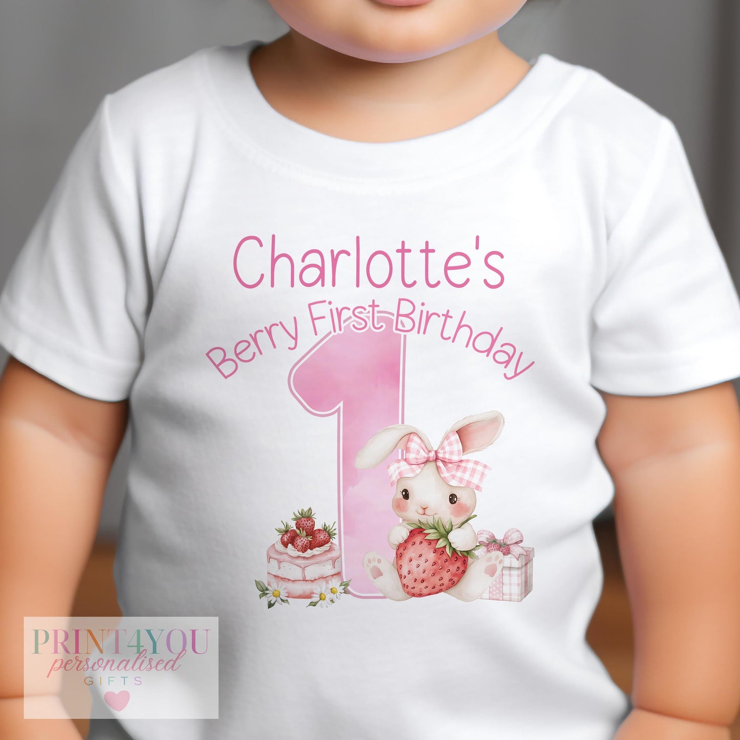 Close-up of the strawberry bunny print and personalised name on the first birthday outfit.