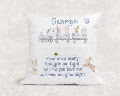 Personalised children's book cushion with blue train design propped on a chair