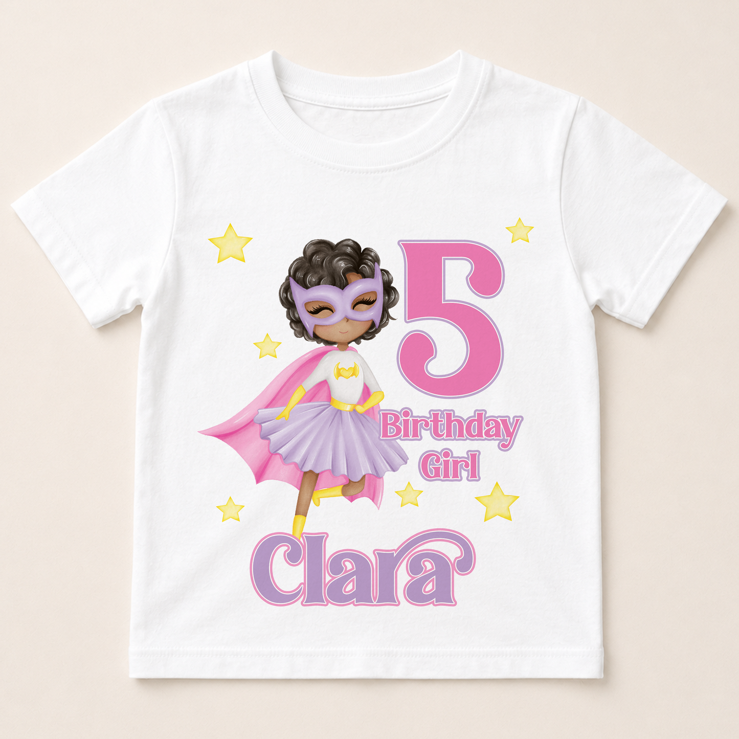 A white t-shirt with a graphic design featuring a young girl wearing a superhero costume, surrounded by stars and the number 5.