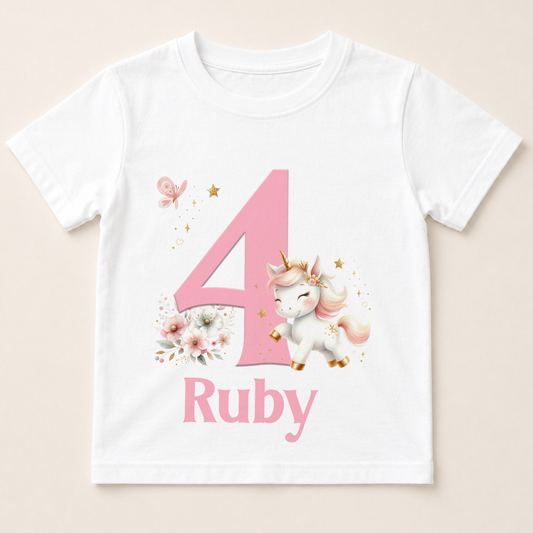 Personalised unicorn birthday t-shirt example, printed with a custom name and number in pink on white cotton.