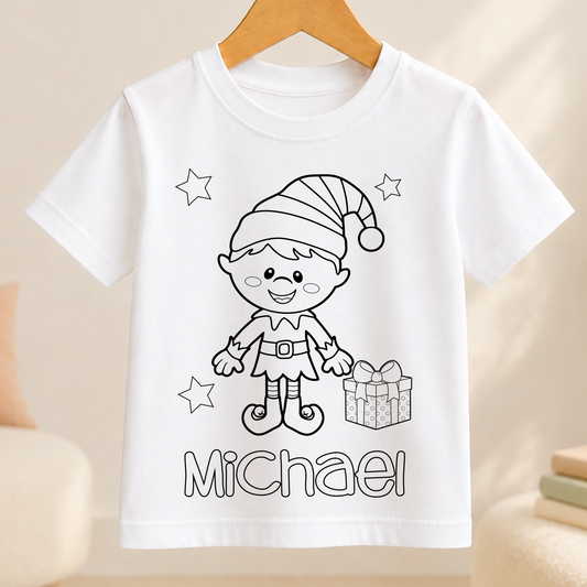 A white t-shirt with a black and white illustration of a smiling elf character wearing a hat and holding a gift box. The name "Michael" is written below the illustration.