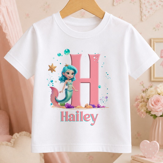 A white t-shirt with a mermaid character and the name "Hailley" printed on it.