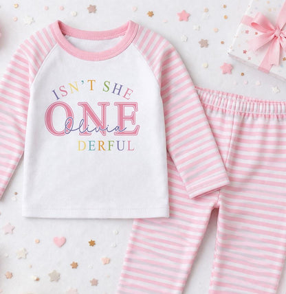 Personalised pink 1st birthday pyjama set printed with 'Isn't she ONE-derful' and the child's name