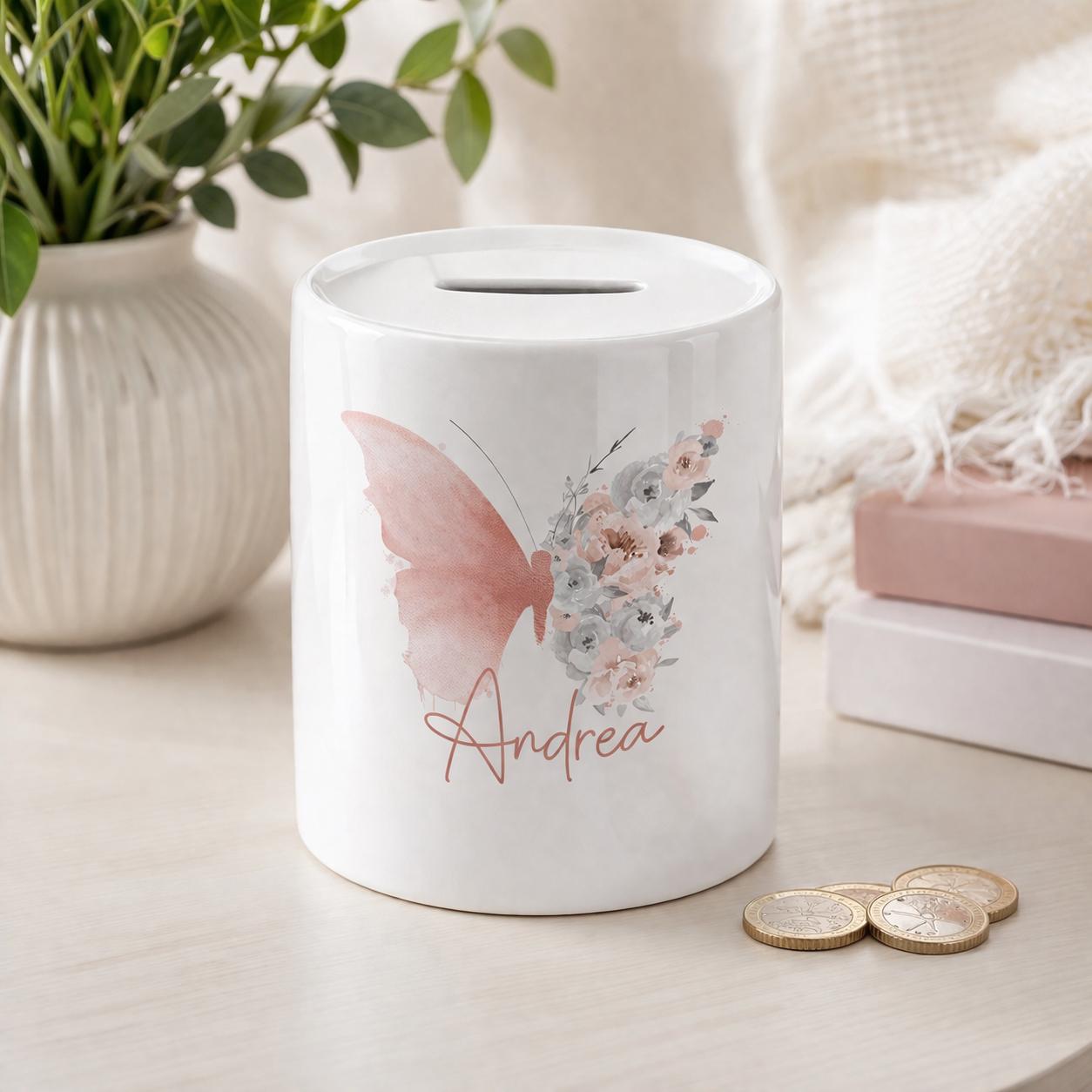 White ceramic money box personalised with the name Andrea, printed with a watercolour butterfly and blush floral bouquet design