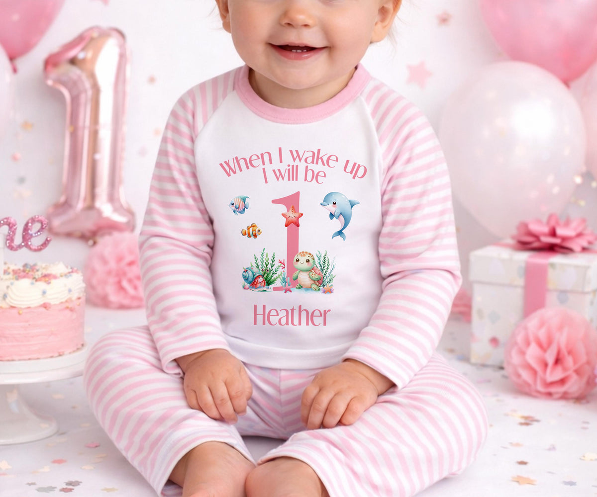 Personalised first birthday outfit printed with a custom name on soft cotton, front view.