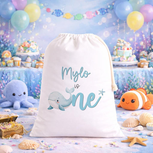 Personalised whale birthday sack laid flat, showing the printed name and ocean-themed whale design