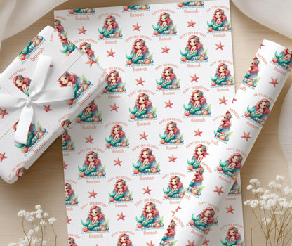 Personalised mermaid wrapping paper wrapped around a gift and tied with ribbon, featuring the pastel mermaid, shell and starfish design.