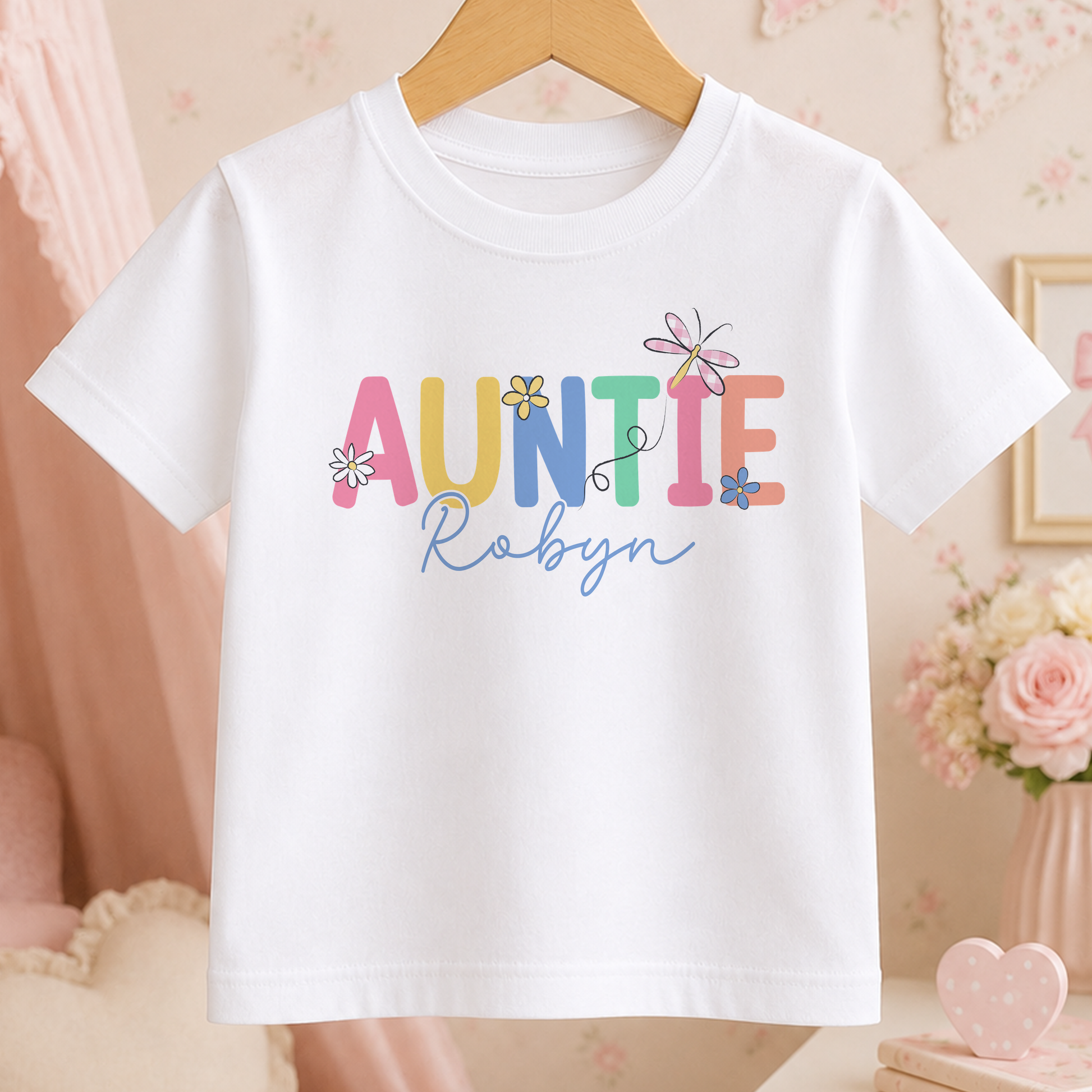 A white t-shirt with the text "Auntie Robyn" printed on it, along with colorful flower designs.