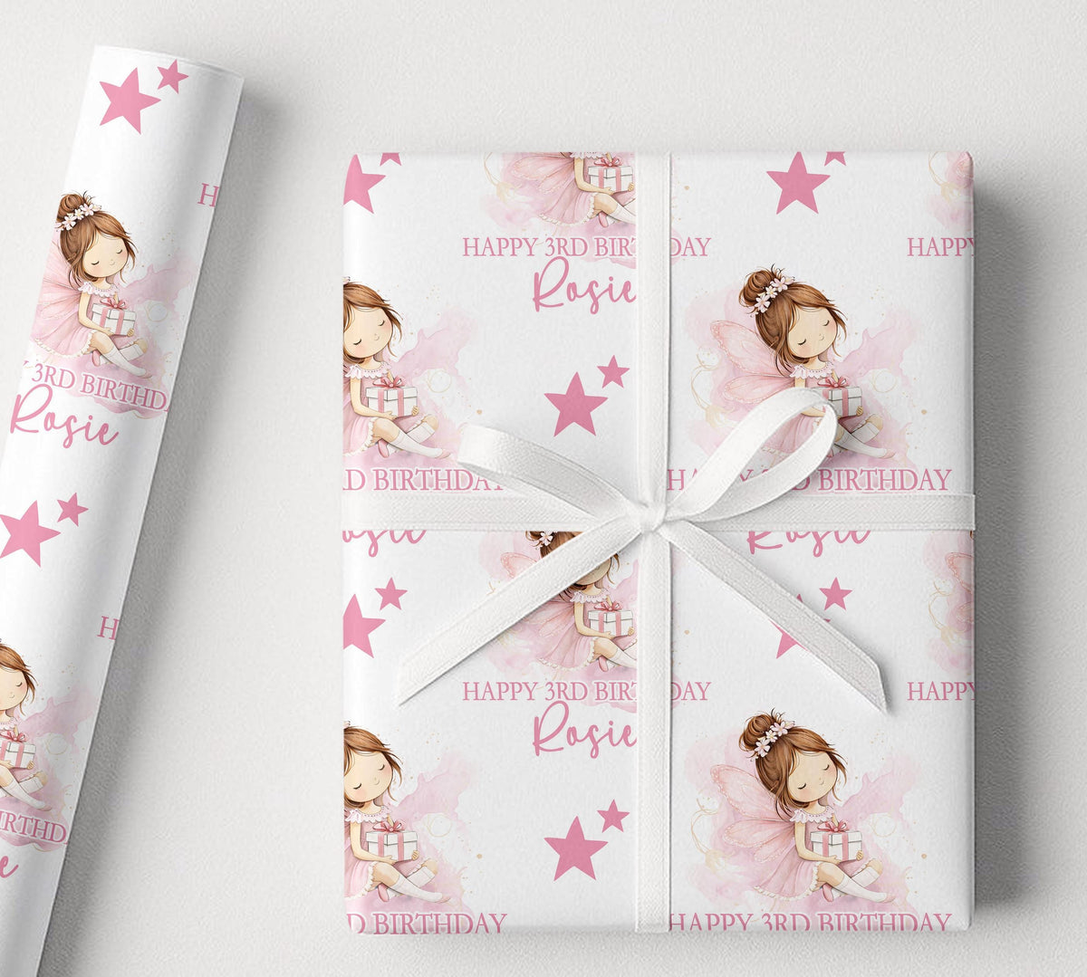 Sheet of personalised pink fairy birthday wrapping paper laid flat