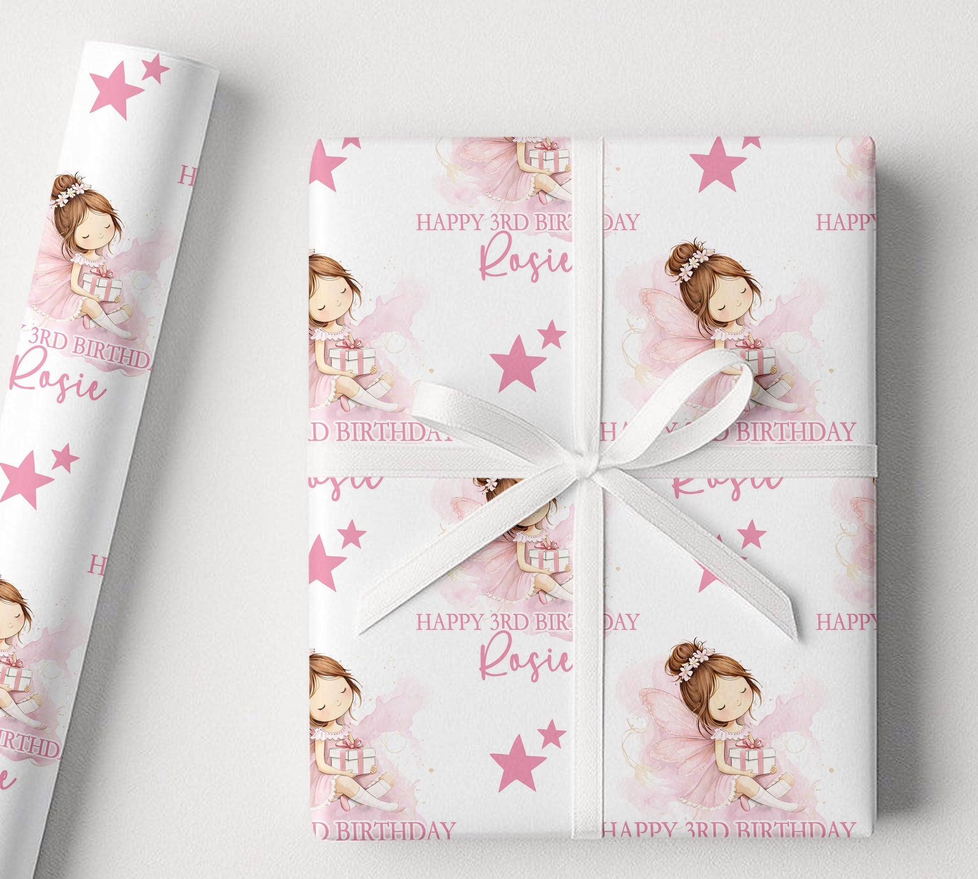 Sheet of personalised pink fairy birthday wrapping paper laid flat