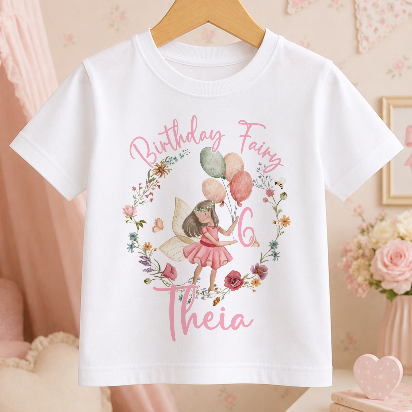 A white t-shirt with a birthday fairy design and the text "Birthday Fairy 6 Theia" printed on it.