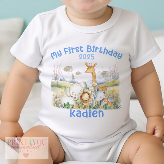 Personalised safari animal first birthday outfit set in pink and blue, laid flat on a soft cotton background.