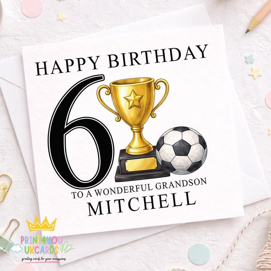 White square birthday card reading 'Happy Birthday 6, To A Wonderful Grandson, Mitchell', illustrated with a gold trophy topped with a star and a black-and-white football, standing on a wooden surface with confetti and a pencil