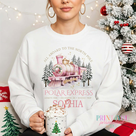 Woman wearing personalised Polar Express Christmas jumper with pink train design and custom name printed below, size X Small
