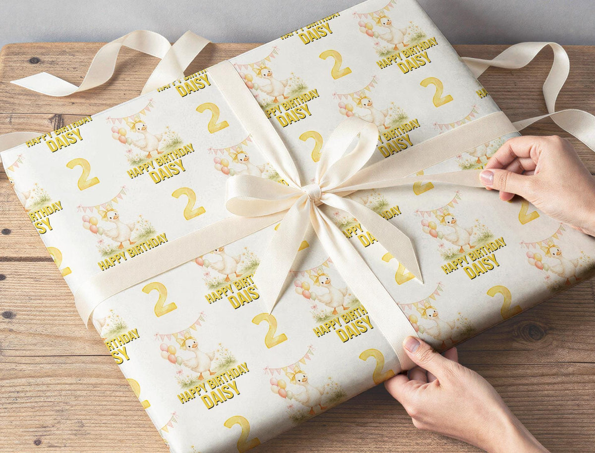 Personalised yellow duck balloon birthday wrapping paper laid flat, showing the repeating pastel pattern.