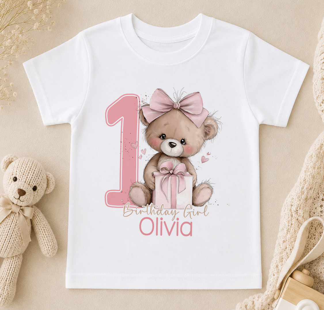 Pink teddy bear first birthday design shown on a personalised Birthday Girl t-shirt with custom name.