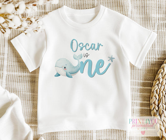 Personalised ocean whale first birthday bib printed with child's name, 'Making Waves' design