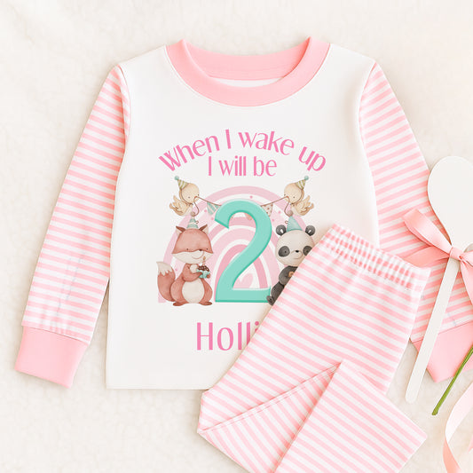 Pink and white striped pyjama set printed with 'When I wake up I will be 2 Hollie', featuring a fox and a panda in party hats.