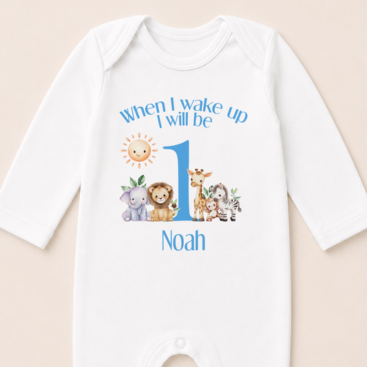 Personalised blue safari first birthday vest printed with lion, giraffe, elephant and zebra illustrations and baby's name.