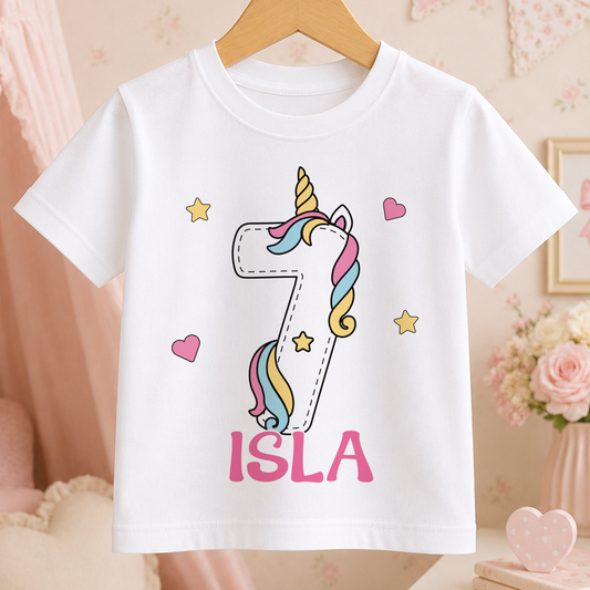 A white t-shirt with a unicorn graphic and the number 7 printed on it, along with the name "ISA" written below.