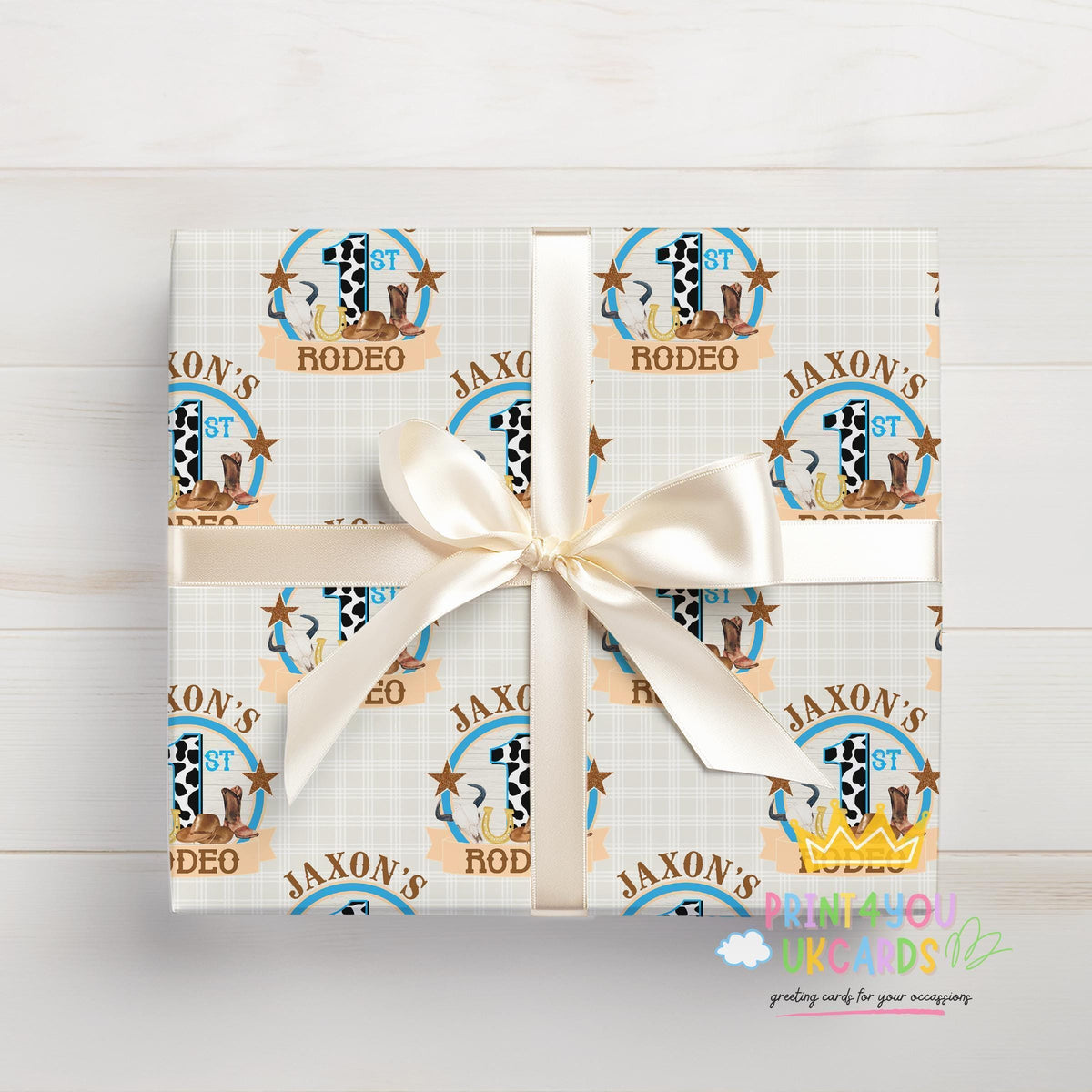 Gift box wrapped in personalised cowboy rodeo wrapping paper with a cowboy hat and bull pattern and white ribbon.