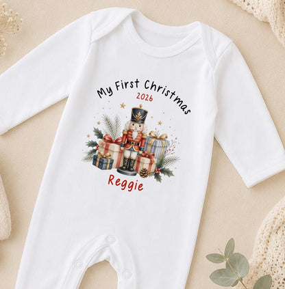 Personalised baby first Christmas sleepsuit in white cotton printed with a nutcracker design, My First Christmas and baby's name