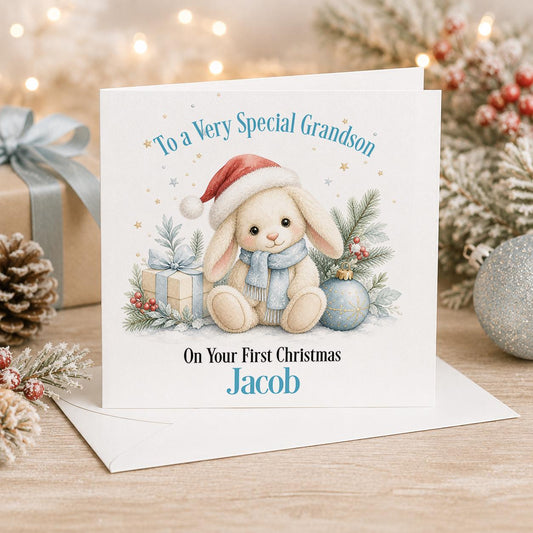 Personalised baby first Christmas card, white 6x6 inch square card printed with a bunny in a Santa hat and baubles with a name