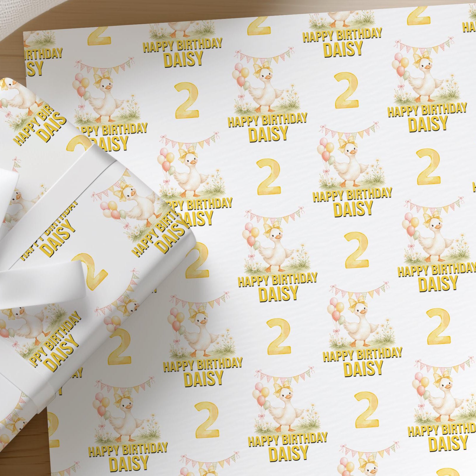 Roll of personalised duck wrapping paper with an example name and age printed on the design