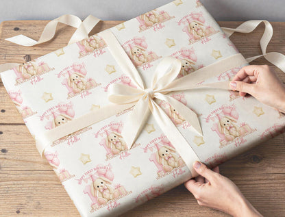 Personalised bunny wrapping paper wrapped around a gift with ribbon, featuring the custom name, pink number one and balloons.