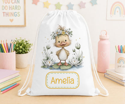 Drawstring nursery bag printed with a duck and floral design, personalised with a child's name across the front