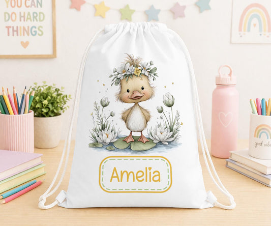 Drawstring nursery bag printed with a duck and floral design, personalised with a child's name across the front