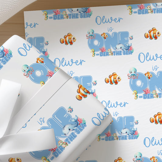 The image is a gift wrapping with a pattern featuring the name "Oliver" and various sea creatures such as fish, octopuses, and seahorses.