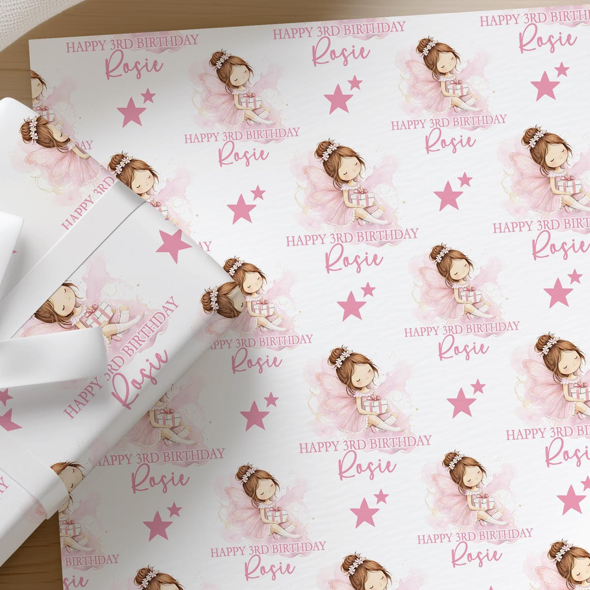 Roll of personalised pink fairy birthday wrapping paper printed with a name and age
