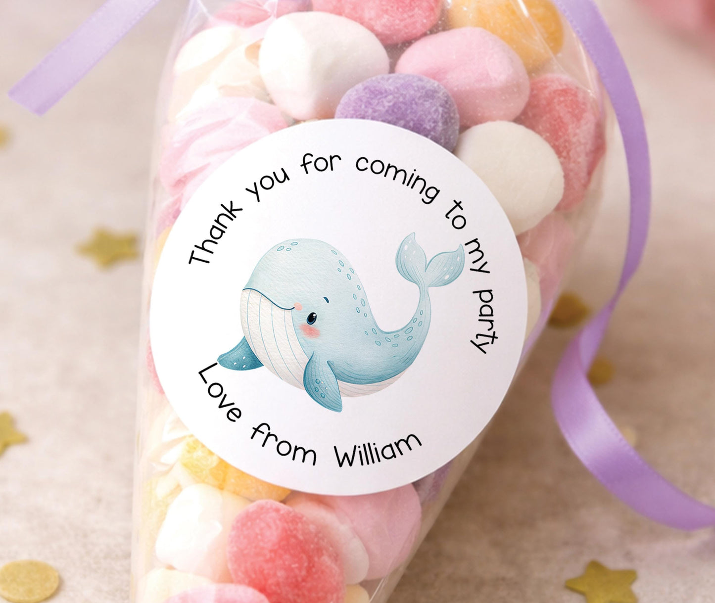 Sheet of round glossy stickers featuring a whale design, personalised with a child's name, for party bags and sweet cones.